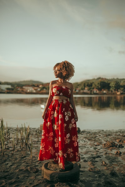 女人穿红色和白色花边无袖褶马克西礼服
